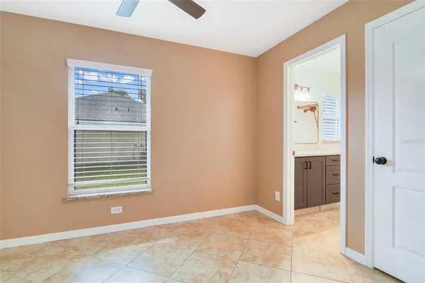a view of an empty room with closet and a window