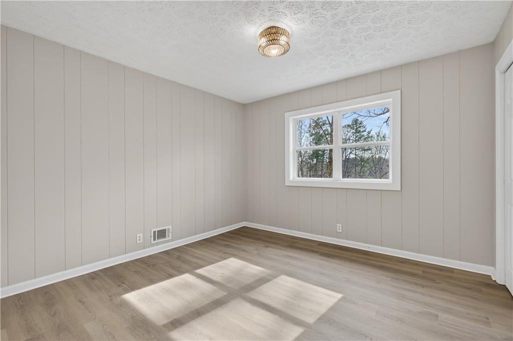 237 Lusk Court Canton, GA 30114 - Photo 13 of 25 an empty room with wooden floor and window