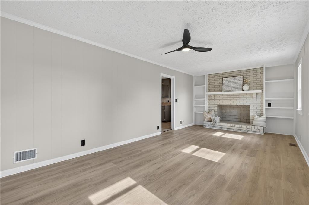 237 Lusk Court Canton, GA 30114 - Photo 4 of 25 a view of empty room with wooden floor and fireplace
