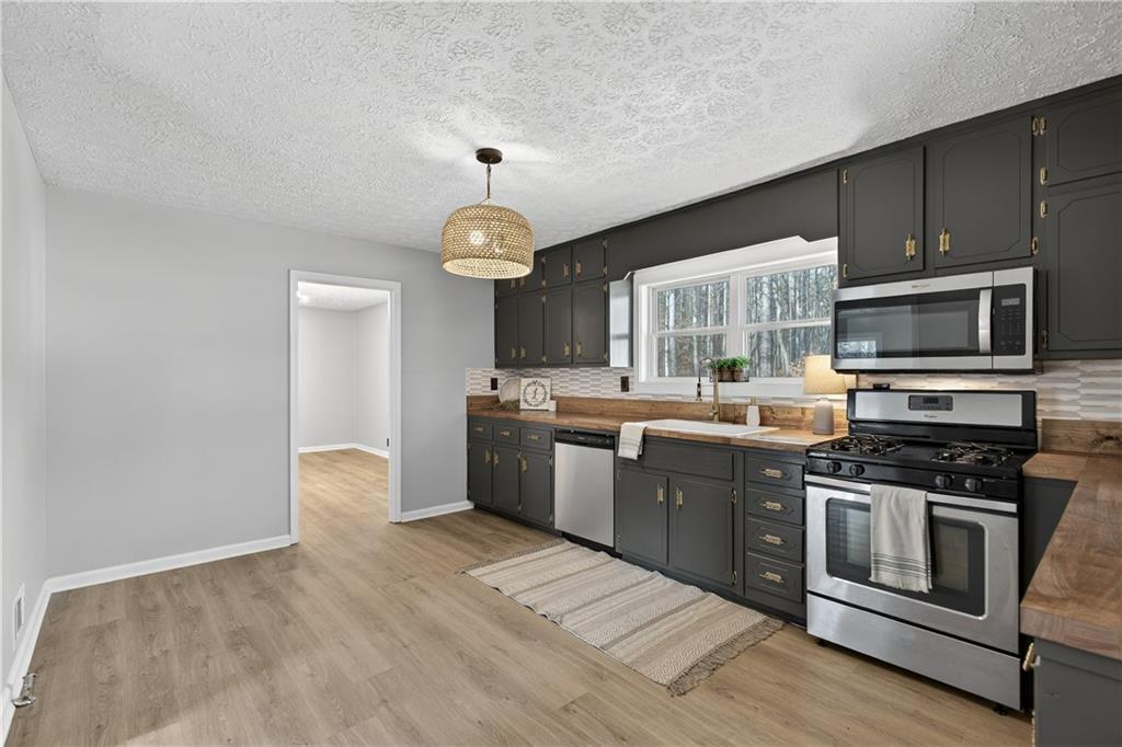 237 Lusk Court Canton, GA 30114 - Photo 6 of 25 a kitchen with stainless steel appliances granite countertop a stove a sink and a microwave
