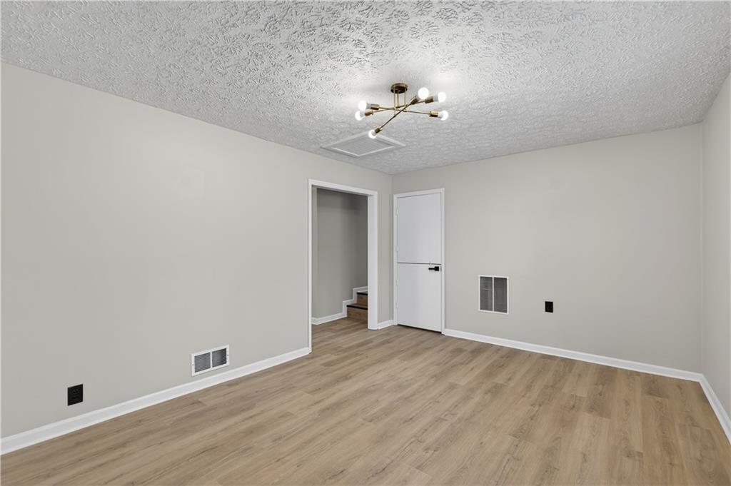 237 Lusk Court Canton, GA 30114 - Photo 8 of 25 a view of an empty room with wooden floor