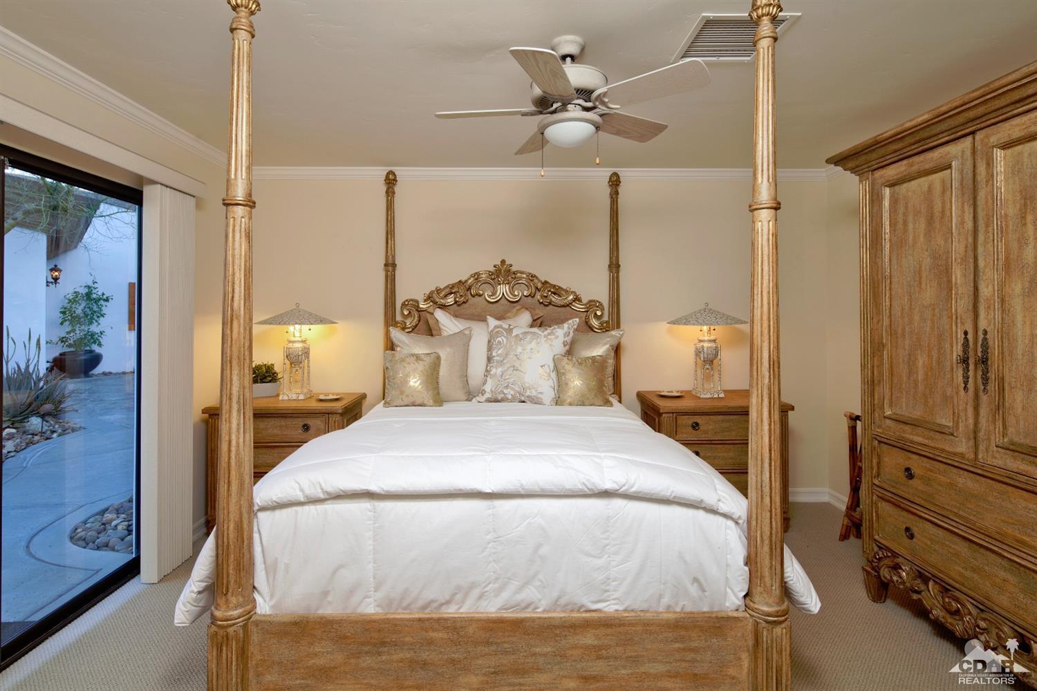 40815 Tonopah Road Rancho Mirage, CA 92270 - Photo 26 of 44 a bedroom with a bed and a chandelier