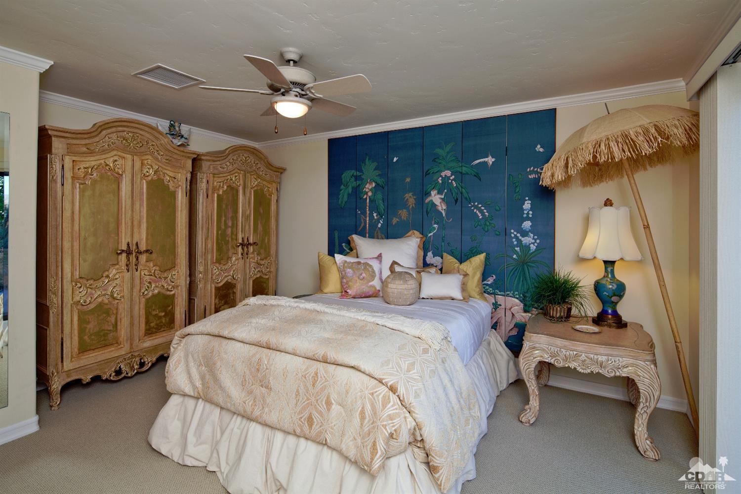 40815 Tonopah Road Rancho Mirage, CA 92270 - Photo 29 of 44 a spacious bedroom with a bed and a chandelier