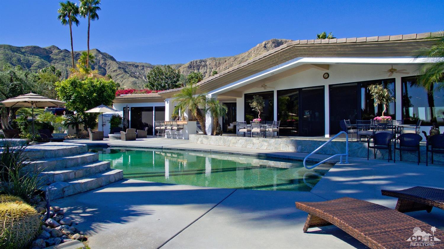 40815 Tonopah Road Rancho Mirage, CA 92270 - Photo 35 of 44 a view of a patio with couches table and chairs potted plants and palm tree
