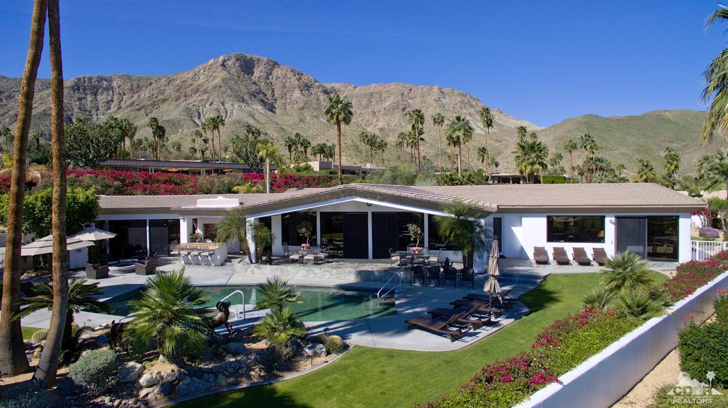 40815 Tonopah Road Rancho Mirage, CA 92270 - Photo 38 of 44 a view of a patio with couches table and chairs under an umbrella