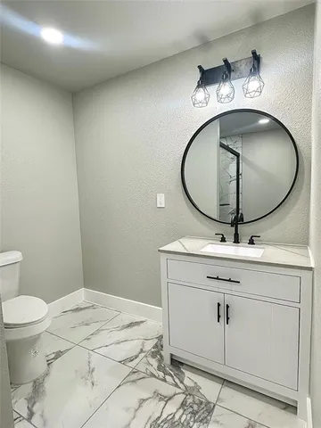 a bathroom with a sink mirror vanity and toilet