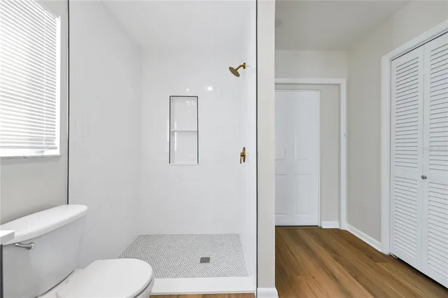 a bathroom with a toilet and a shower
