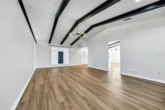 a view of empty room with wooden floor
