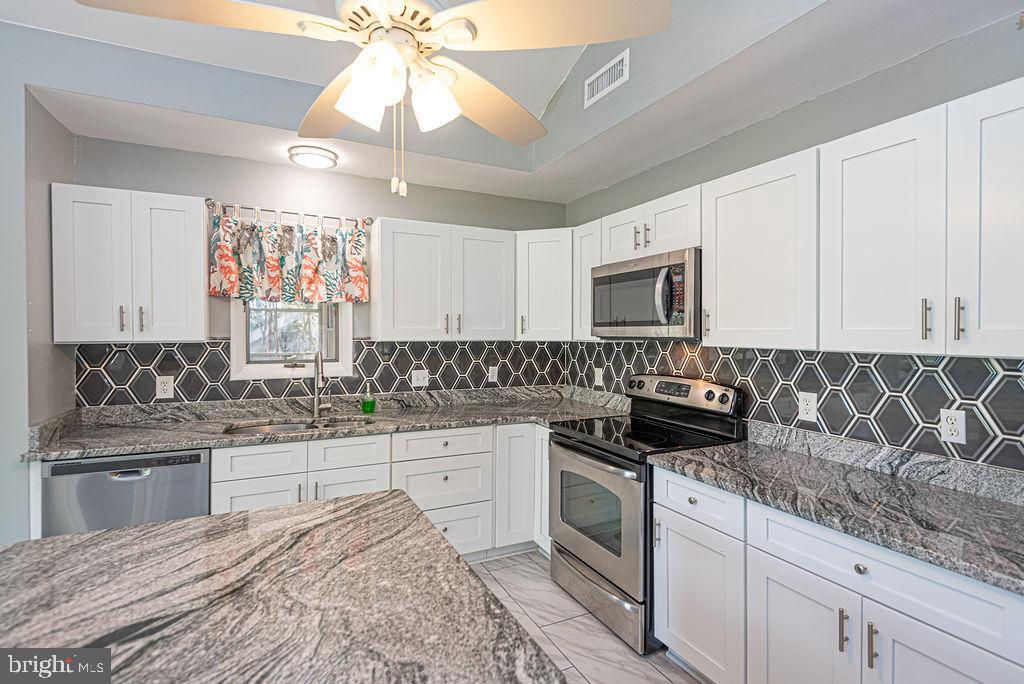 63 Drawbridge Road Ocean Pines, MD 21811 - Photo 20 of 102 a kitchen with a sink stove and cabinets