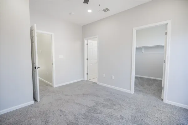 an empty room with closet and a bathroom