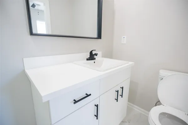 a bathroom with a sink a toilet and mirror