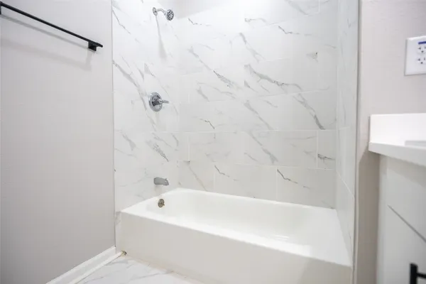 a white bath tub sitting next to a white sink and vanity