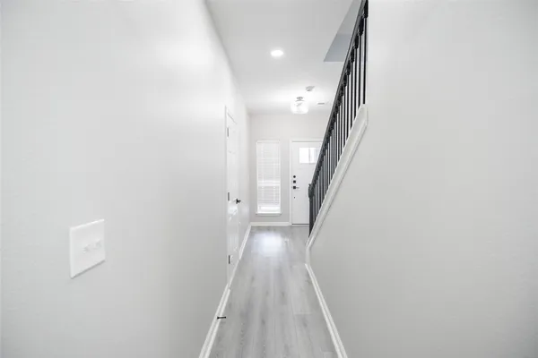 a view of a hallway with wooden floor and staircase