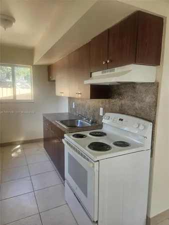 a kitchen with a sink and a stove top oven