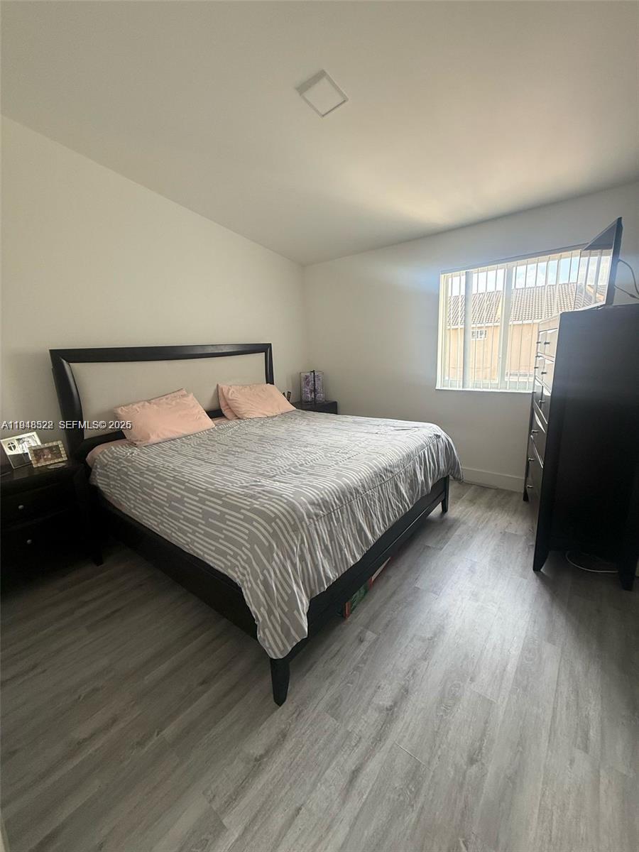 14085 Southwest 179th Terrace Miami, FL 33177 - Photo 16 of 24 a bedroom with a bed and wooden floor