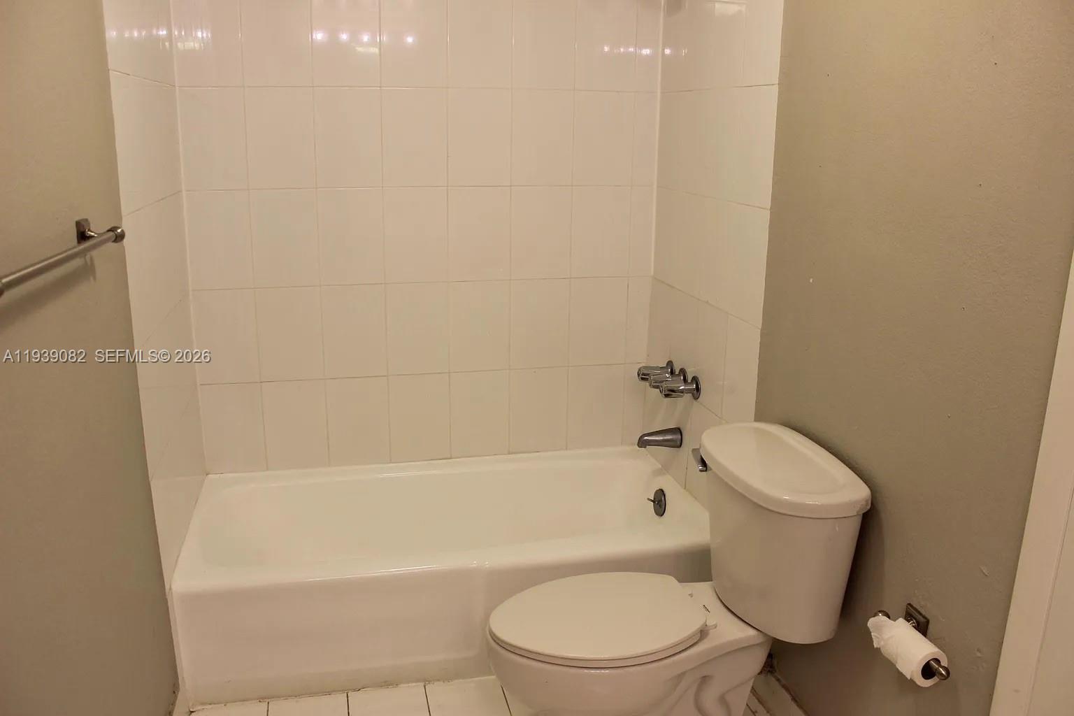 9441 Southwest 76th Street, Unit V33 Miami, FL 33173 - Photo 11 of 21 a white toilet sitting next to a bath tub