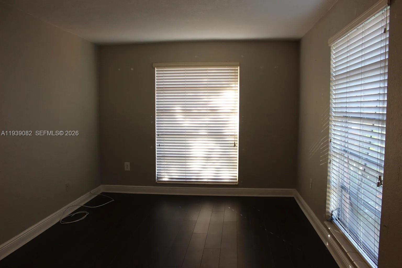 9441 Southwest 76th Street, Unit V33 Miami, FL 33173 - Photo 12 of 21 an empty room with wooden floor and windows