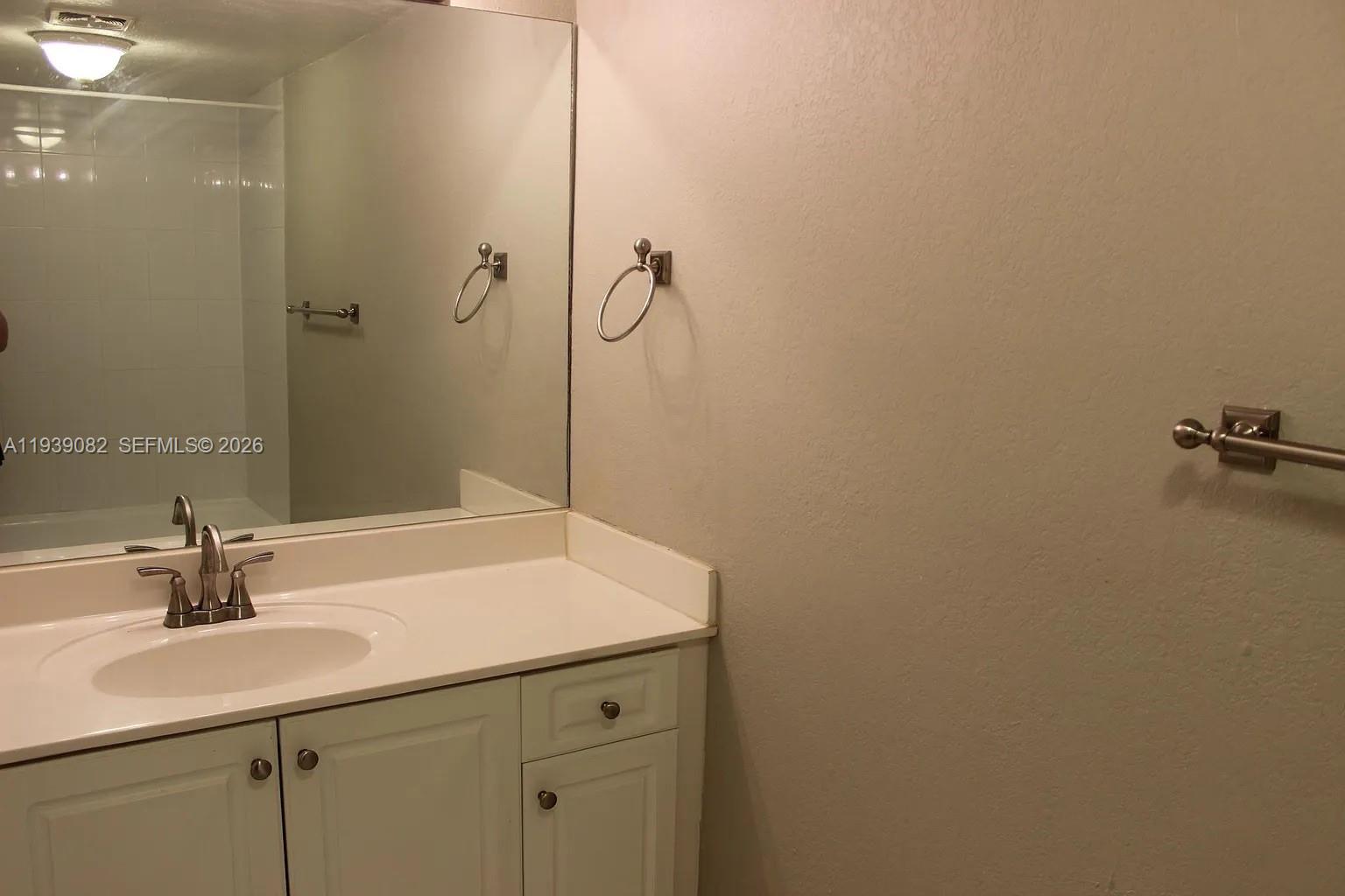 9441 Southwest 76th Street, Unit V33 Miami, FL 33173 - Photo 15 of 21 a bathroom with a sink and a mirror