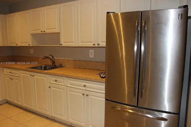 a kitchen with white cabinets and black appliances