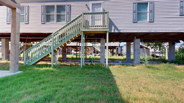 a view of house with a yard and stairs