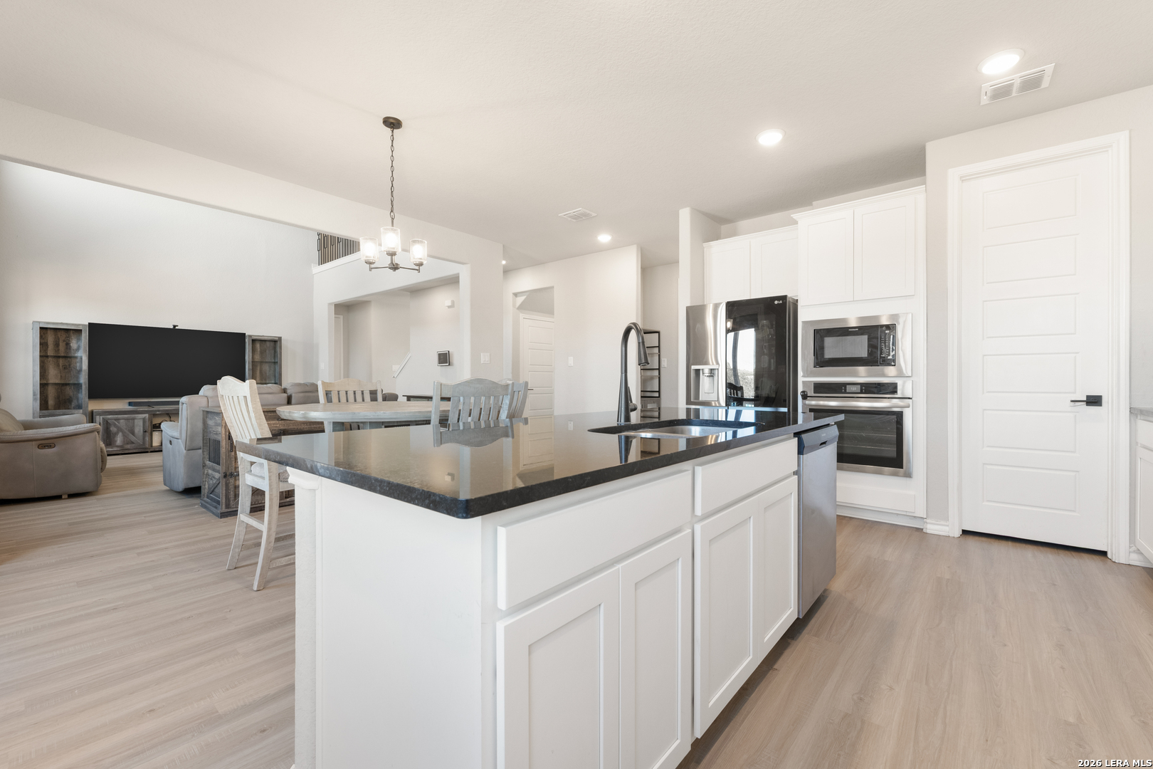 229 Jereth Crossing Castroville, TX 78009 - Photo 16 of 41 a kitchen with stainless steel appliances kitchen island granite countertop a sink and cabinets