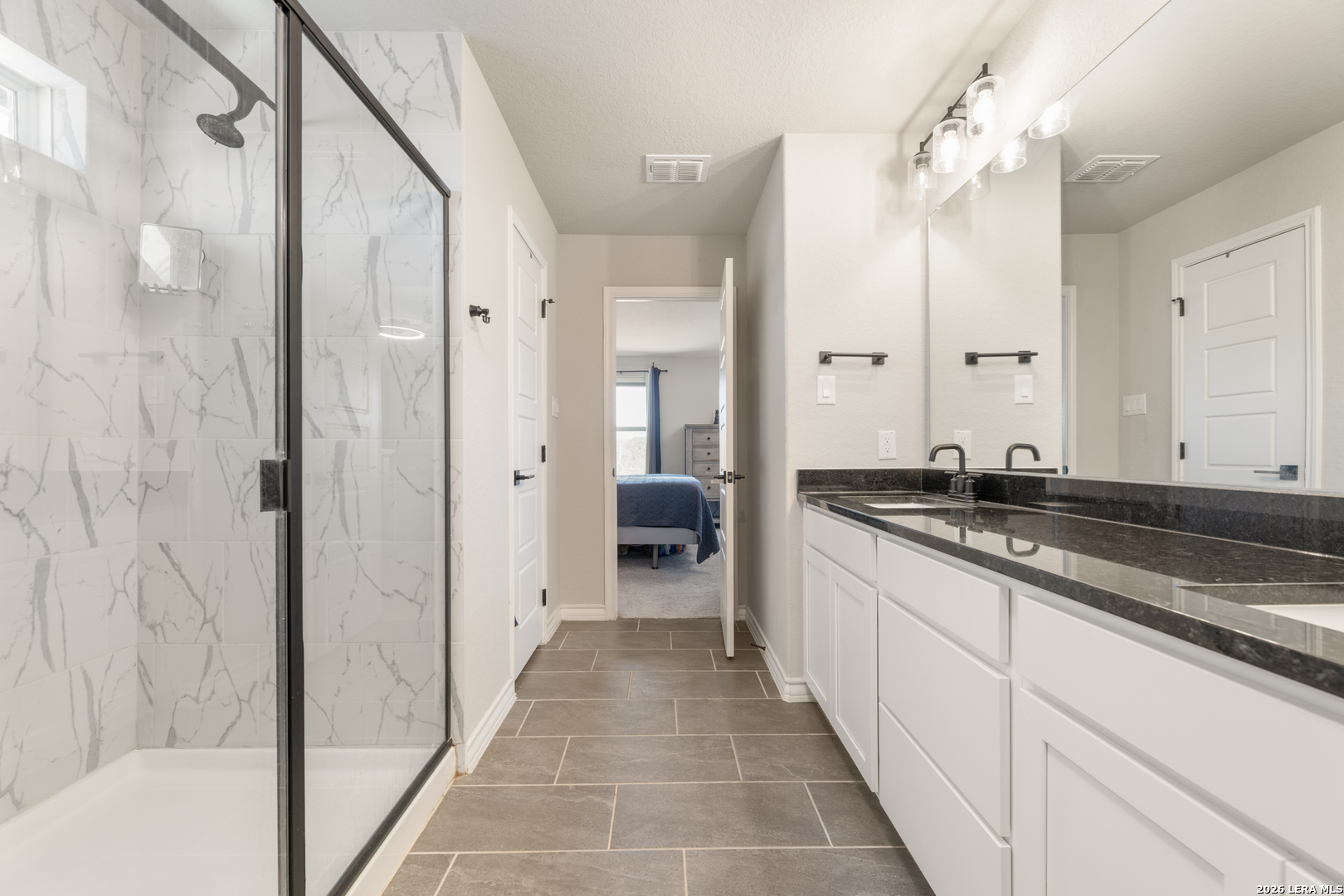 229 Jereth Crossing Castroville, TX 78009 - Photo 29 of 41 a large bathroom with a granite countertop sink a toilet a mirror and shower