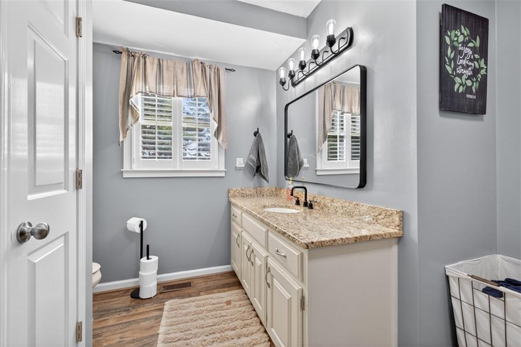 2380 Camp Mitchell Road Grayson, GA 30017 - Photo 25 of 56 a bathroom with a double vanity sink a toilet and a window