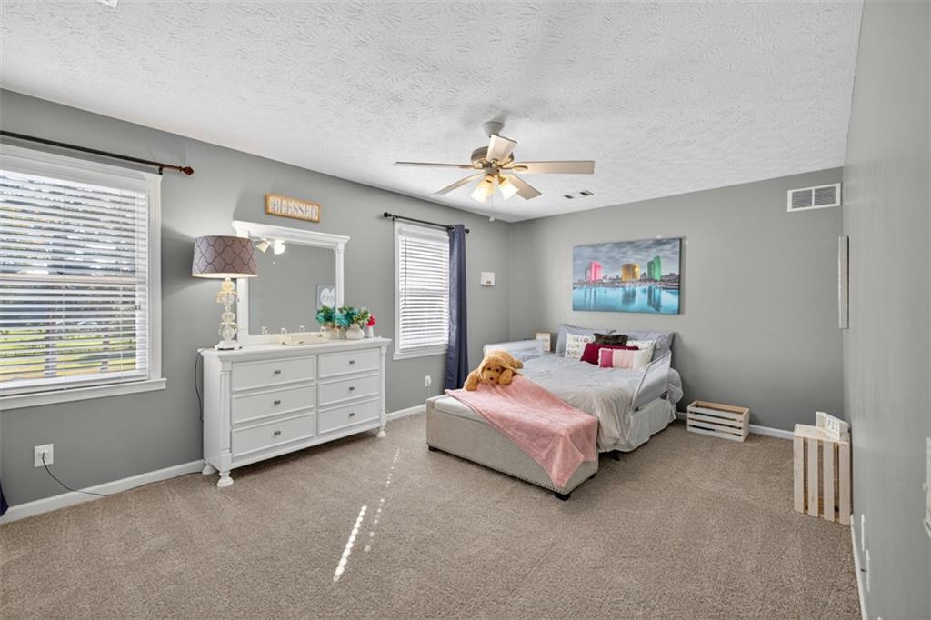 2380 Camp Mitchell Road Grayson, GA 30017 - Photo 32 of 56 a bedroom with furniture and a chandelier