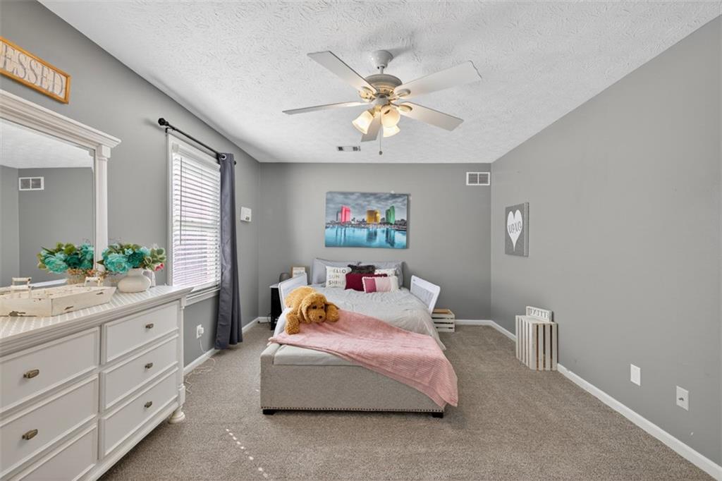 2380 Camp Mitchell Road Grayson, GA 30017 - Photo 33 of 56 a bedroom with a bed and a chandelier