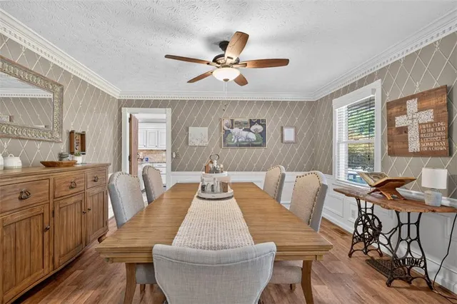 a dining room with furniture a chandelier and wooden floor