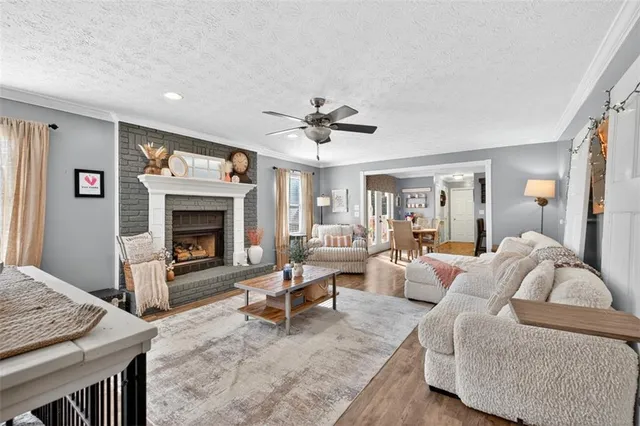 a living room with furniture a fireplace and a chandelier