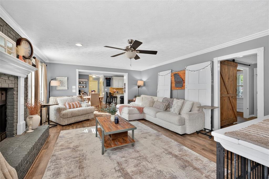 2380 Camp Mitchell Road Grayson, GA 30017 - Photo 10 of 56 a living room with furniture a fireplace and a chandelier