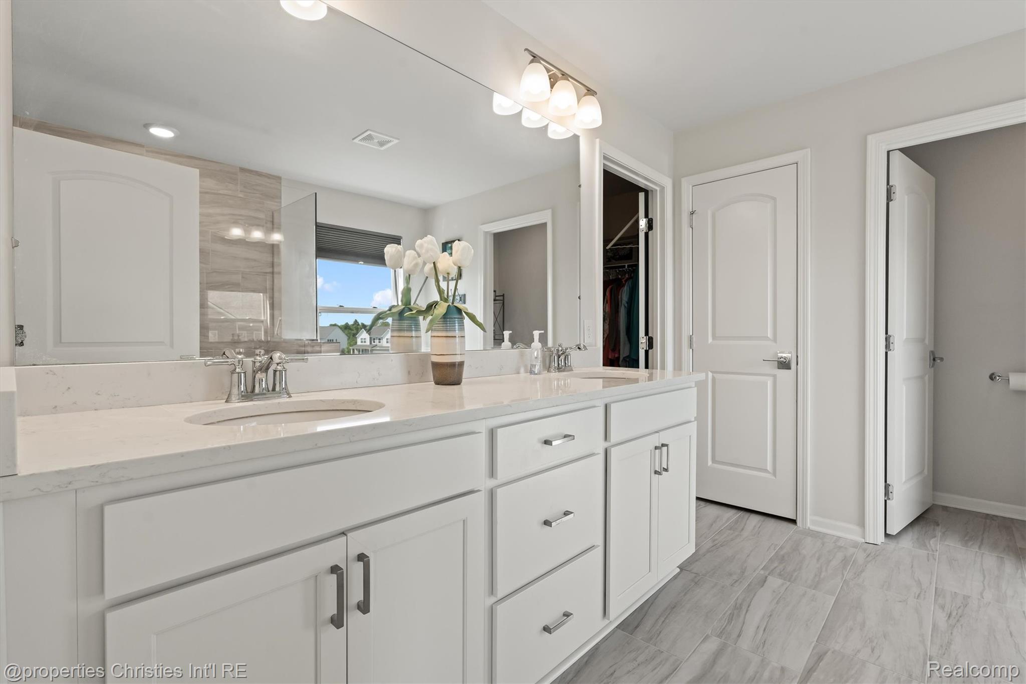 2721 Maize Loop Saline, MI 48176 - Photo 19 of 52 Bathroom featuring double vanity, tiled shower, and a walk in closet