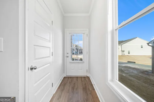 a view of a hallway with wooden floor and a living room
