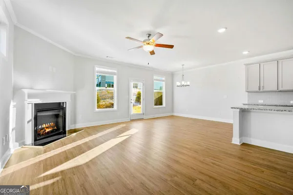 a view of an empty room with a kitchen and a fireplace