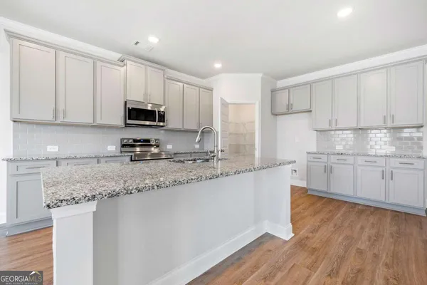 a kitchen with stainless steel appliances granite countertop a sink a stove a microwave and cabinets