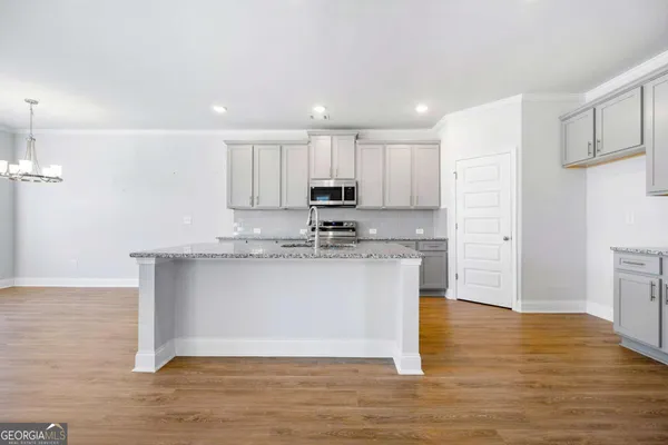 a view of kitchen with granite countertop stainless steel appliances refrigerator sink and stove