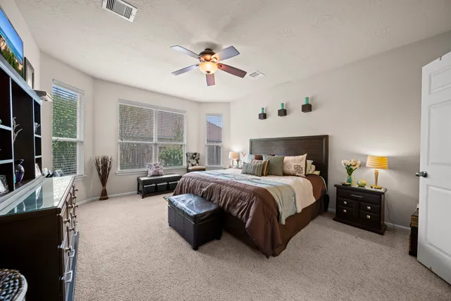 a spacious bedroom with a bed and a chandelier
