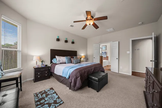 a spacious bedroom with a bed and a chandelier