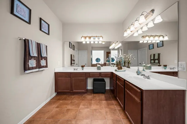a large white kitchen with a sink and dishwasher with a large kitchen island