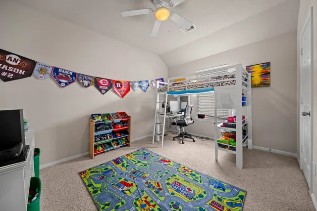 a view of play room with toys and ceiling fan