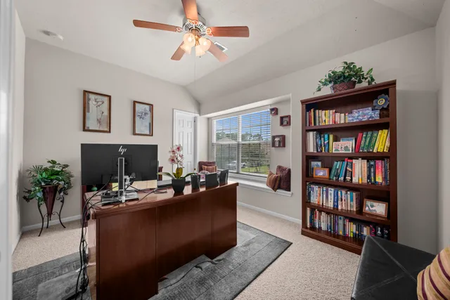 a living room with furniture and a book shelf