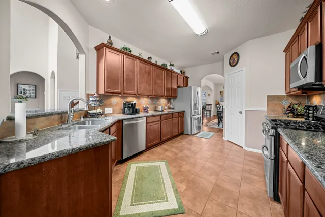 a kitchen with stainless steel appliances granite countertop a stove sink and cabinets