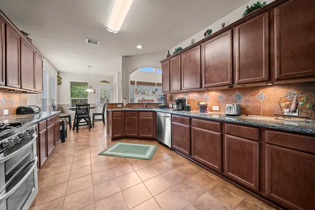 a kitchen with a sink a counter top space appliances and cabinets