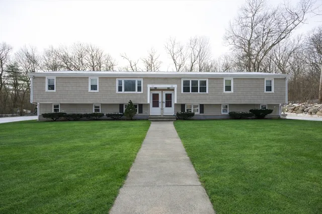 a front view of a house with a garden and yard