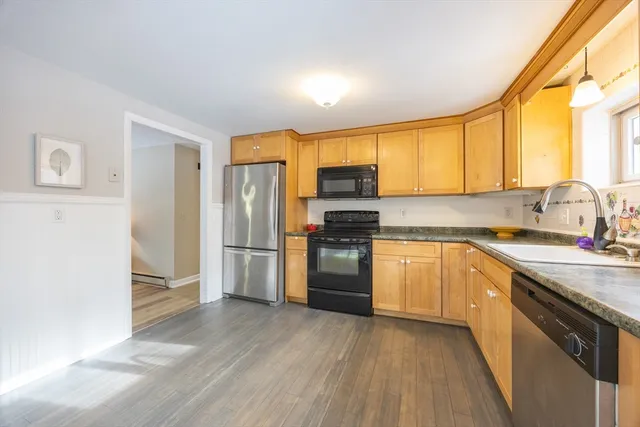 a kitchen with a sink a refrigerator a window and stainless steel appliances