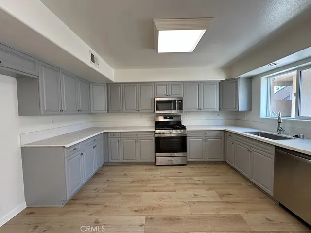 a kitchen with sink a microwave and cabinets