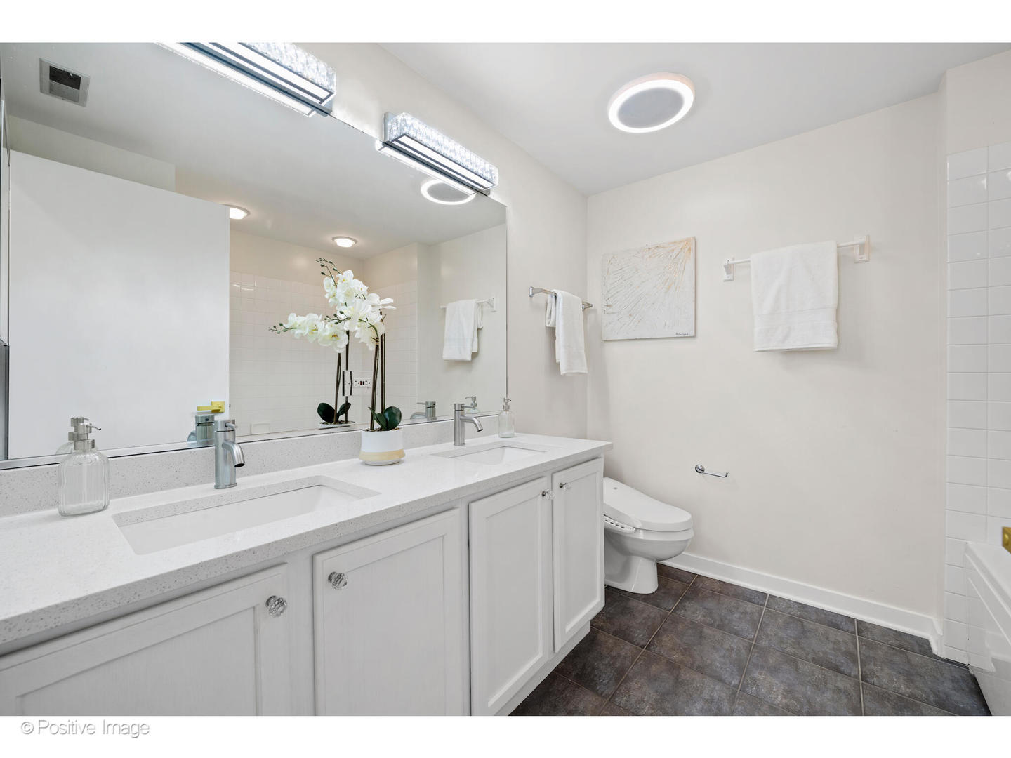 1151 West Washington Boulevard, Unit 136 Chicago, IL 60607 - Photo 13 of 19 a bathroom with a double vanity sink a toilet and a mirror