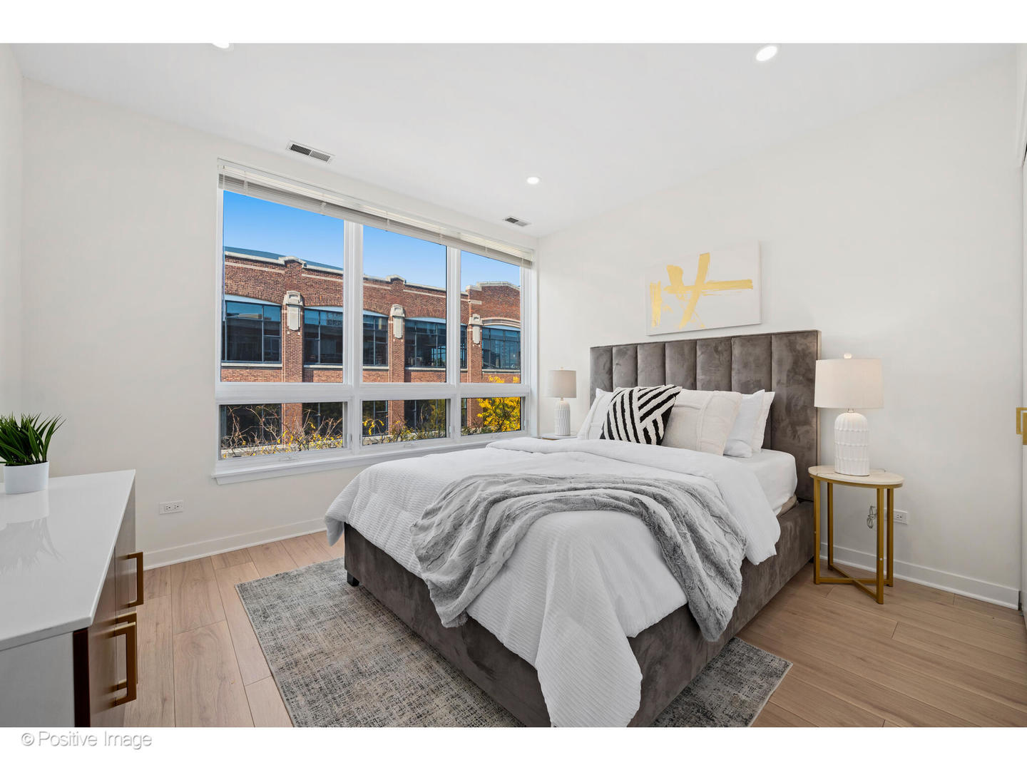 1151 West Washington Boulevard, Unit 136 Chicago, IL 60607 - Photo 14 of 19 a bedroom with a bed a table and a large mirror