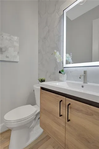 a bathroom with a sink a toilet and mirror